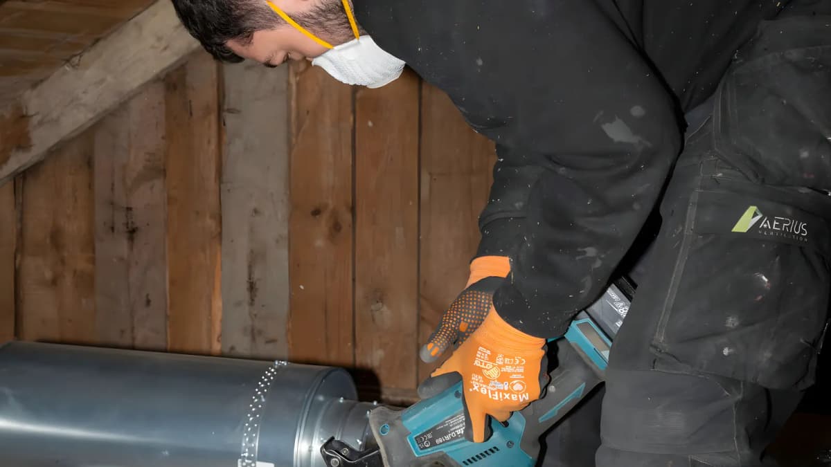 Montör som arbetar med fläkt och kanaler för mekanisk frånluft